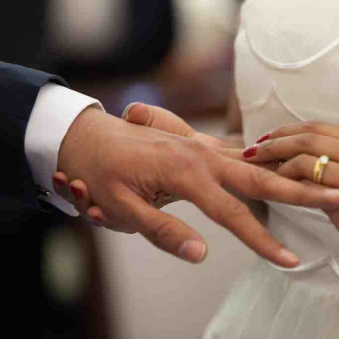 Mulher colocando aliança no dedo do marido