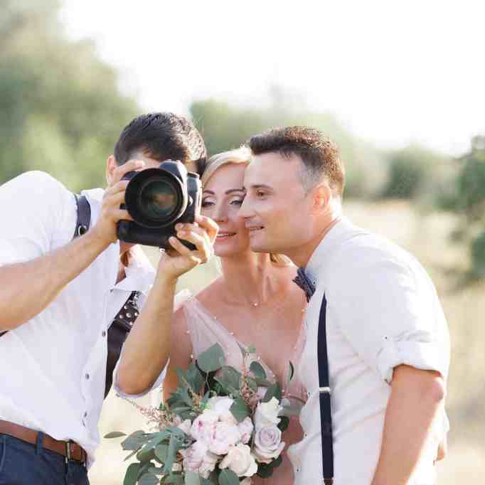 Fotógrafo de casamento mostrando as fotos para os noivos