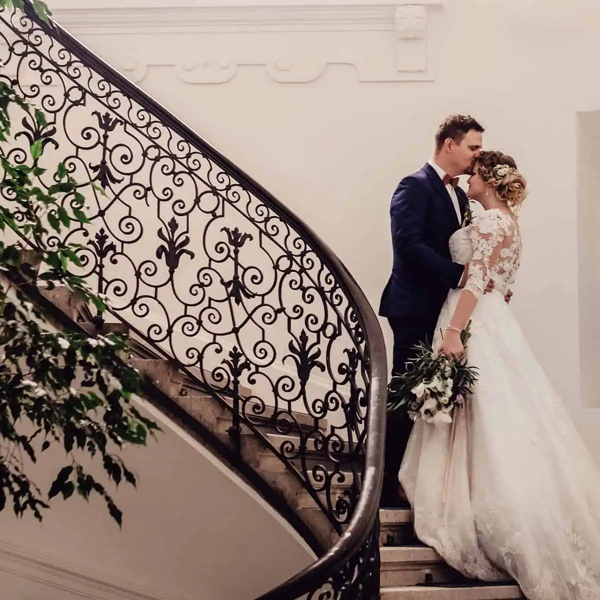 Noivo e noiva se beijando em uma escada