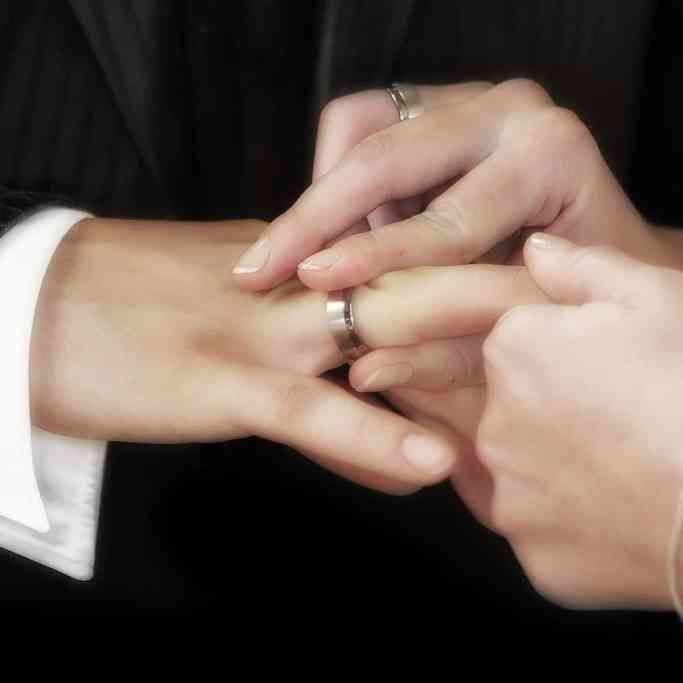 Noiva colocando aliança no dedo do noivo