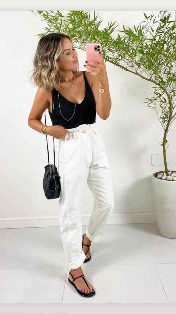 7 Estilos Universais: Quais Joias combinam com Cada um Deles? - Estilo elegante contemporaneo 3 Mulher de regata preta e calça branca- 7 estilos universais: quais joias combinam com cada um deles?