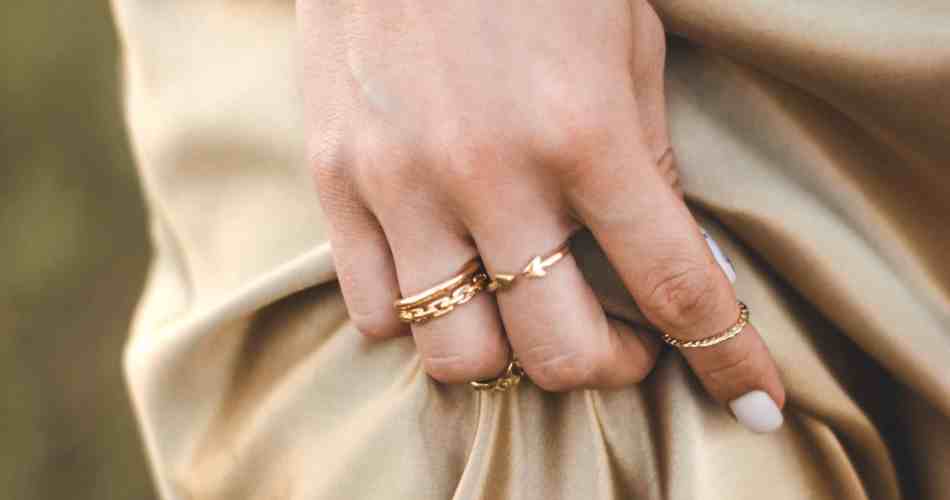 Mulher segurando o vestido usando vários anéis