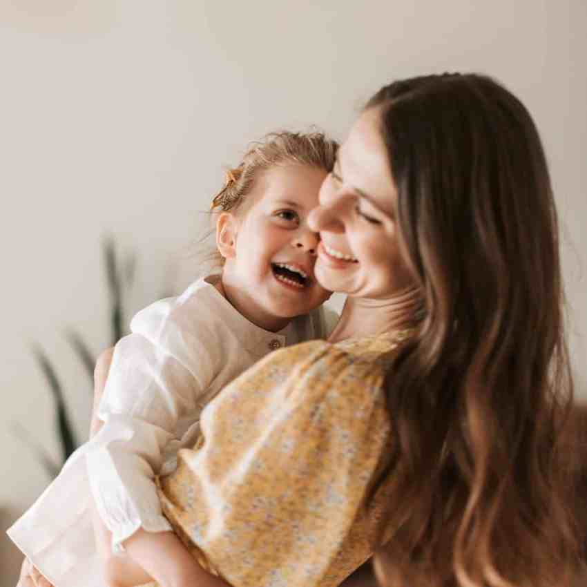 Dia das Mães: 10 Presentes Inesquecíveis e Especiais - Dia das maes o que presentear Mãe segurando a criança no colo e rindo