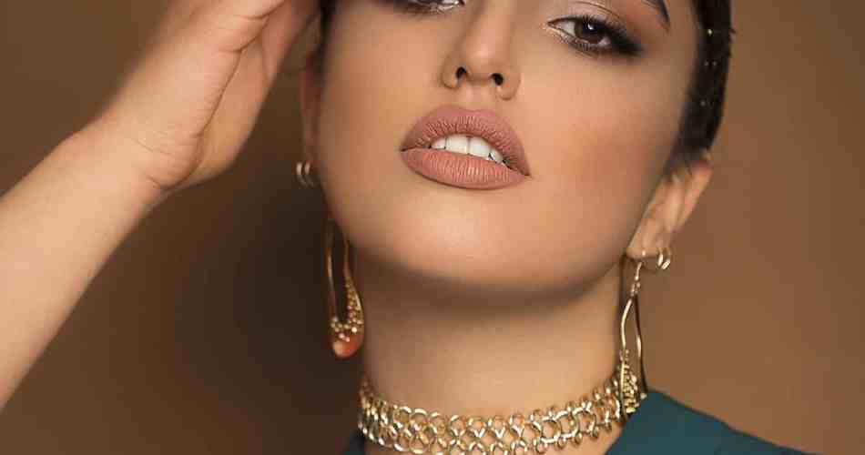 Mulher usando mix de colares e brinco dourado