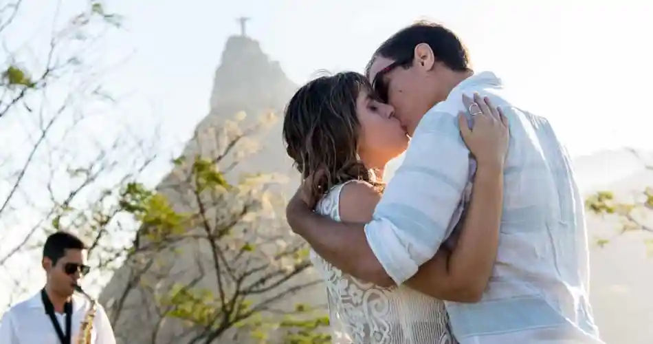 Casal se beijando em frente ao cristo redentor