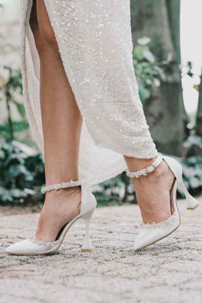 Noiva com vestido de noivado brilhante e sapato de salto com pedras