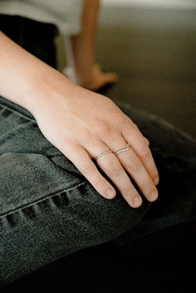 Mulher usando anéis no dedo anelar e médio