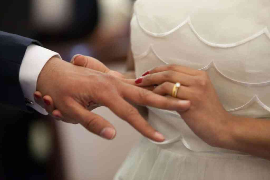 Noiva colocando aliança no dedo do noivo