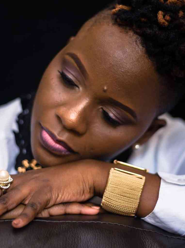 Mulher deitada em cima dos braços usando pulseira e anel