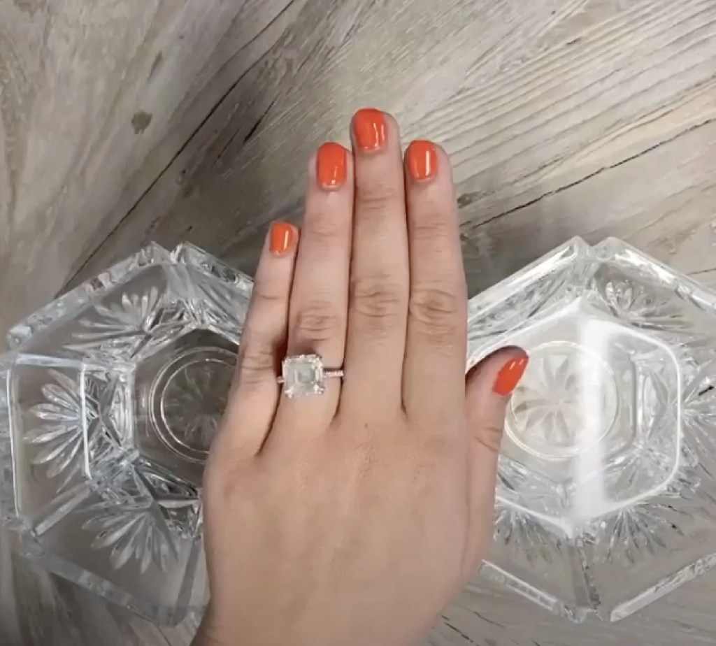 Duas vasilhas com água e mão feminina por cima usando anel de noivado