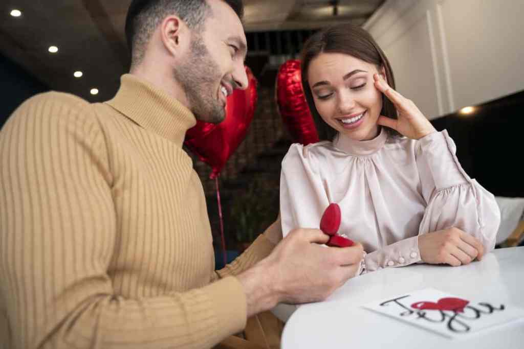 Homem pedindo mulher em namoro em restaurante arás deles tem dois balões em formato de coração