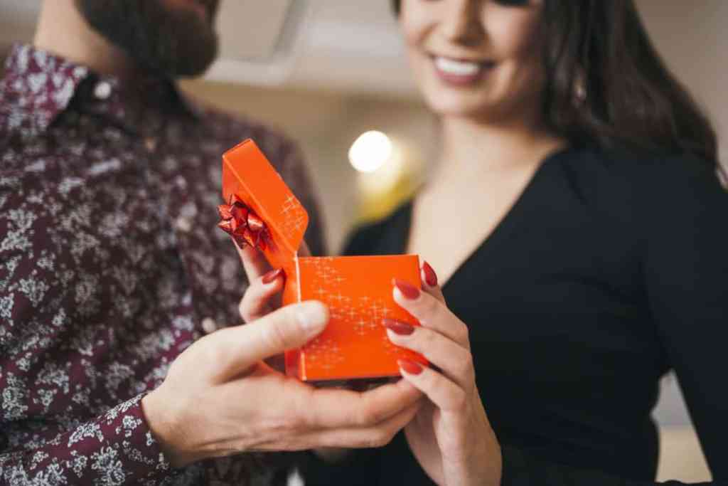 Pedir em casamento nas festas - mulher abrindo caixinha de presente do namorado