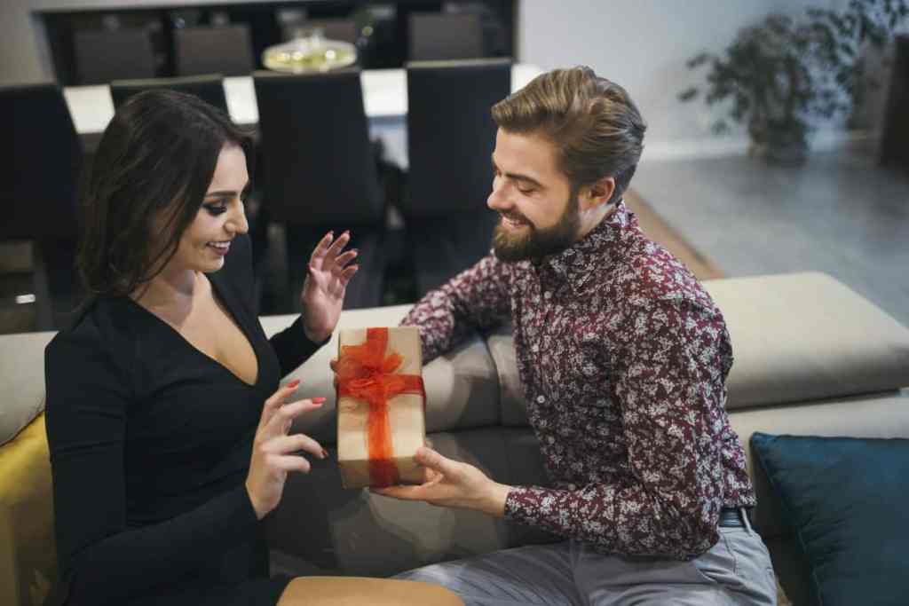 Homem entregando caixinha de presente para mulher
