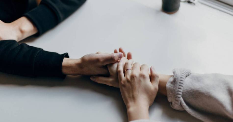 Casal de mão dada em cima de uma mesa