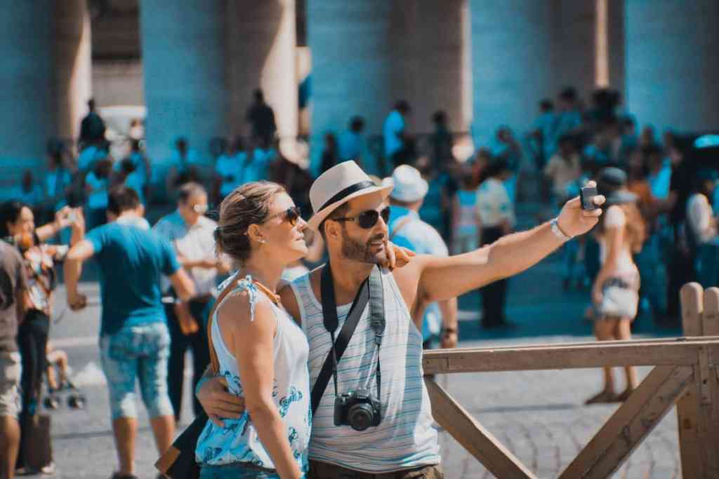 Homem e mulher tirando fotos em ponto turístico