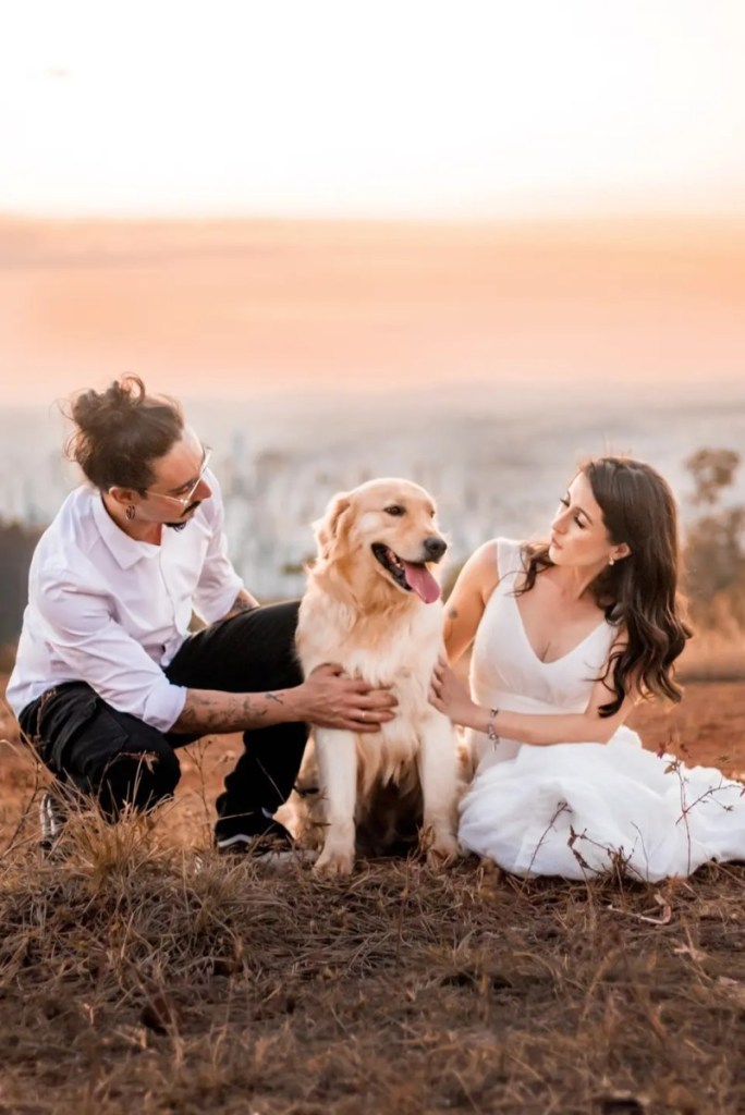Casal de noivos com um cachorro golden