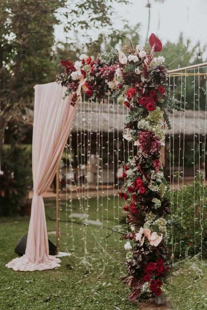 Altar de casamento com flores marsala e pisca piscas