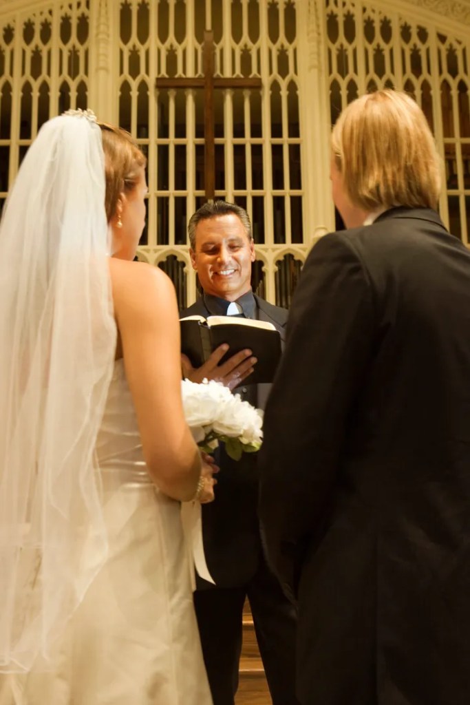 Noivos durante cerimônia de casamento com pastor
