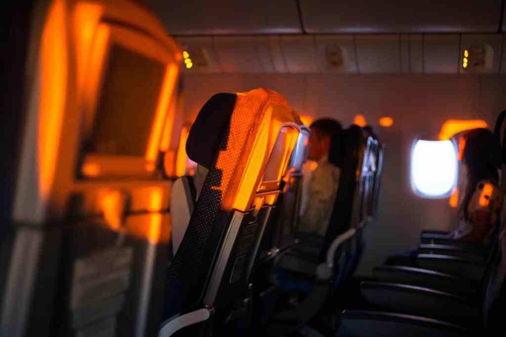 Foto de dentro de um avião, mostrando as cadeiras dos passageiros