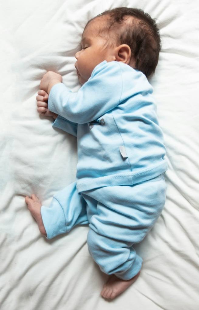 Bebê de roupa azul dormindo