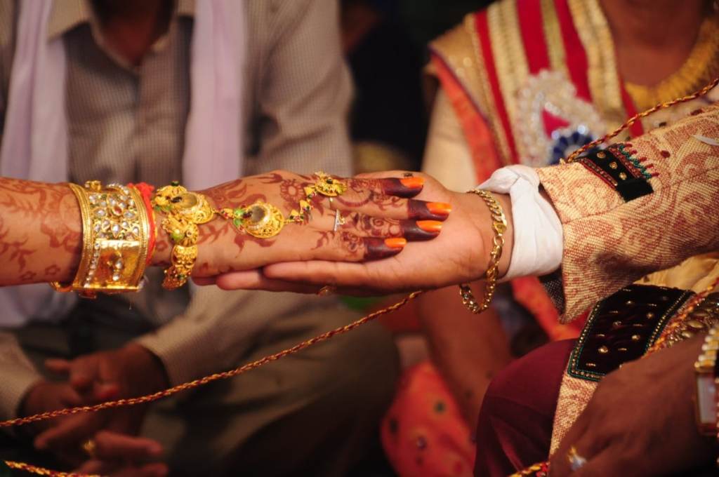 Casamento indiano, os noivos estão com as mãos juntas
