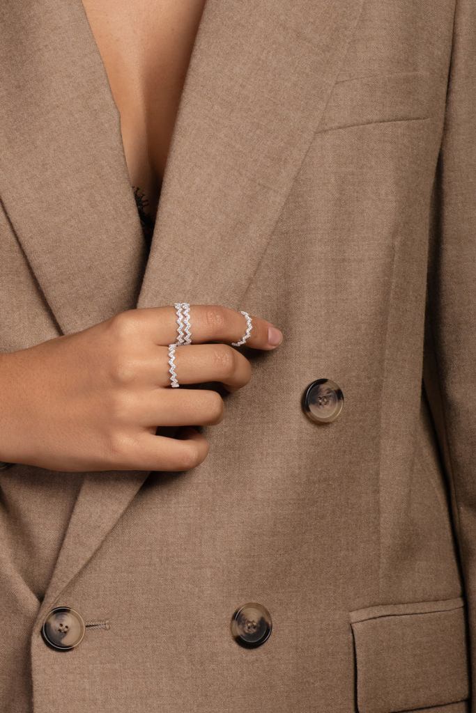 Mulher de blazer usando anéis prata