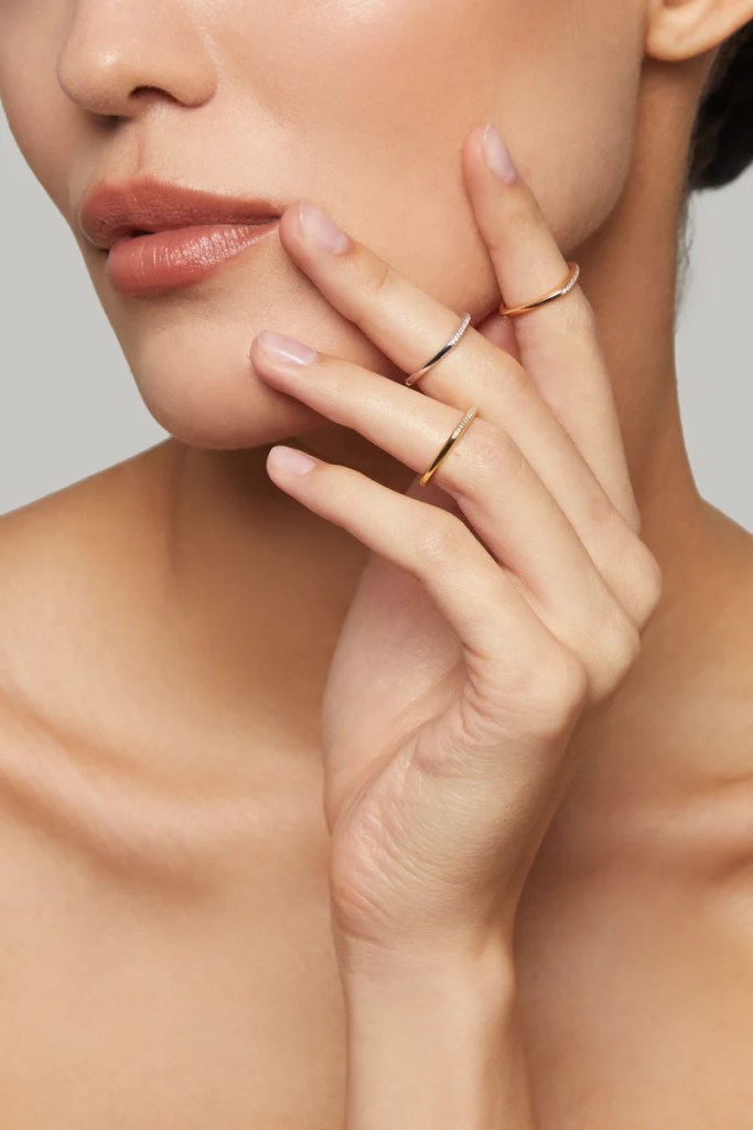 Mulher usando anéis de falange em ouro - anel de falange: o que é e como usar?