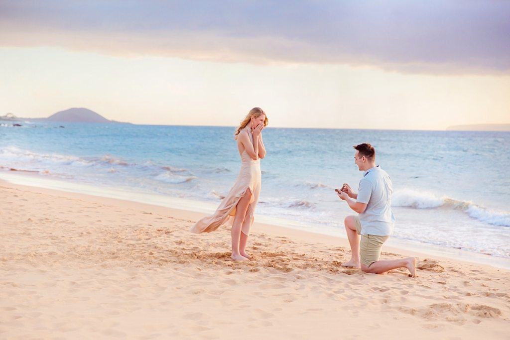 Homem pedindo mulher em casamento na praia.