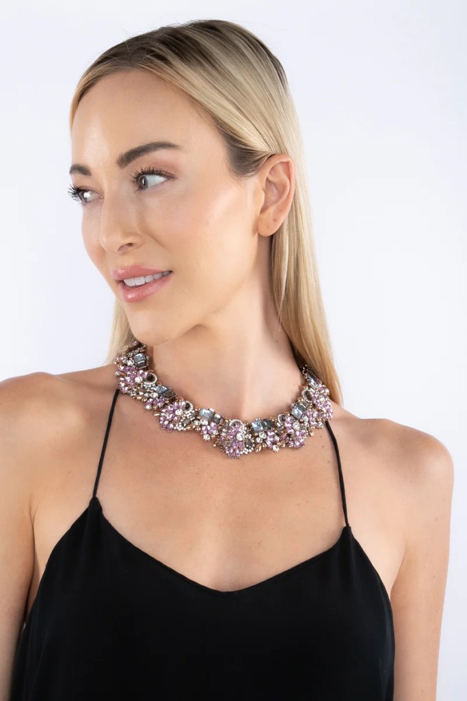 Mulher loira usando colar de diversas pedras lilás, brancas e azuis