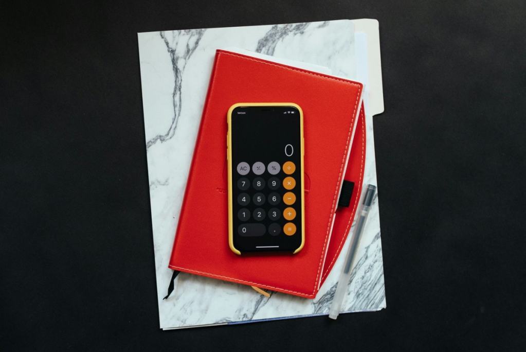 Caderno com celular em cima aberto na calculadora - dicas para escolher o anel perfeito