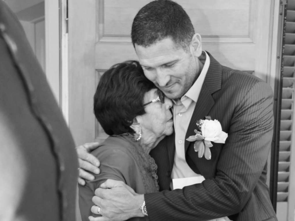 Foto em preto e branco de noivo abraçando sua avó