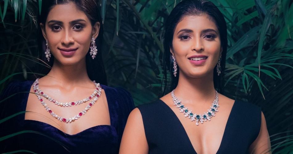 Duas mulheres indianas usando vestido preto e colares com pedras