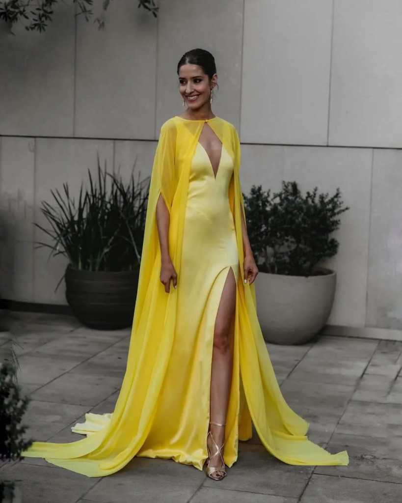 Mulher usando vestido de festa liso amarelo com capa amarela