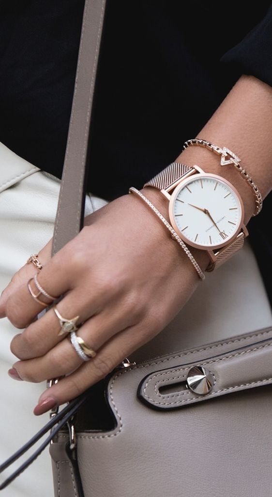 Mulher usando joias e relógio em ouro rosé