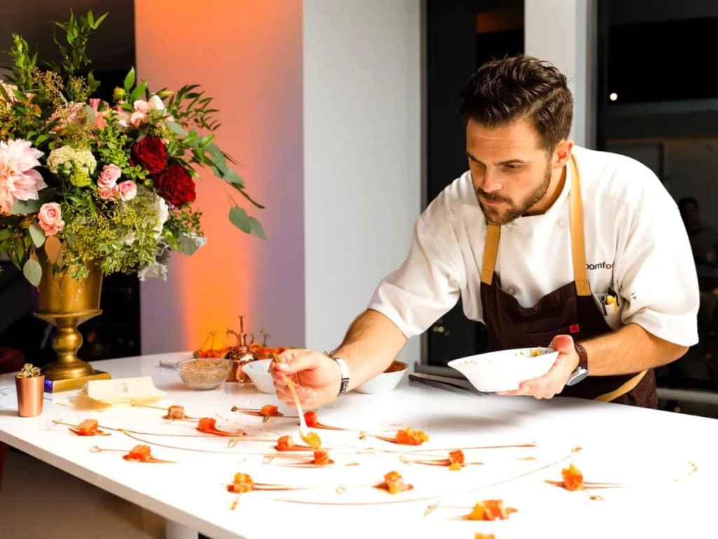 Cozinheiro em casamento colocando petiscos de forma visualmente bonita na mesa