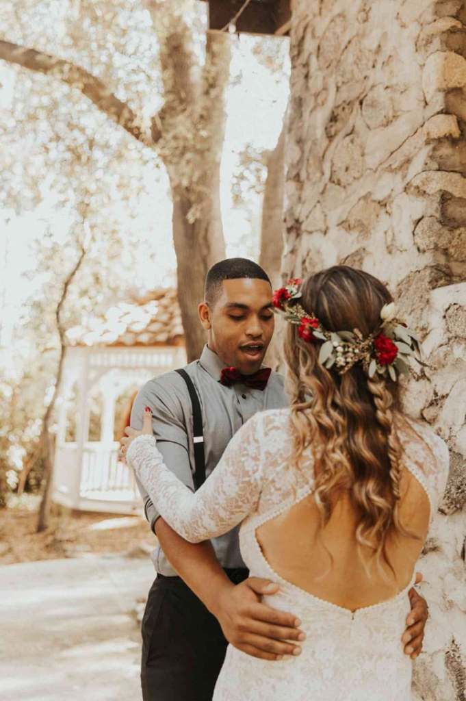 Noivo e noiva fazendo first look, o noivo está com mão na cintura dela e com expressão de surpresa no rosto